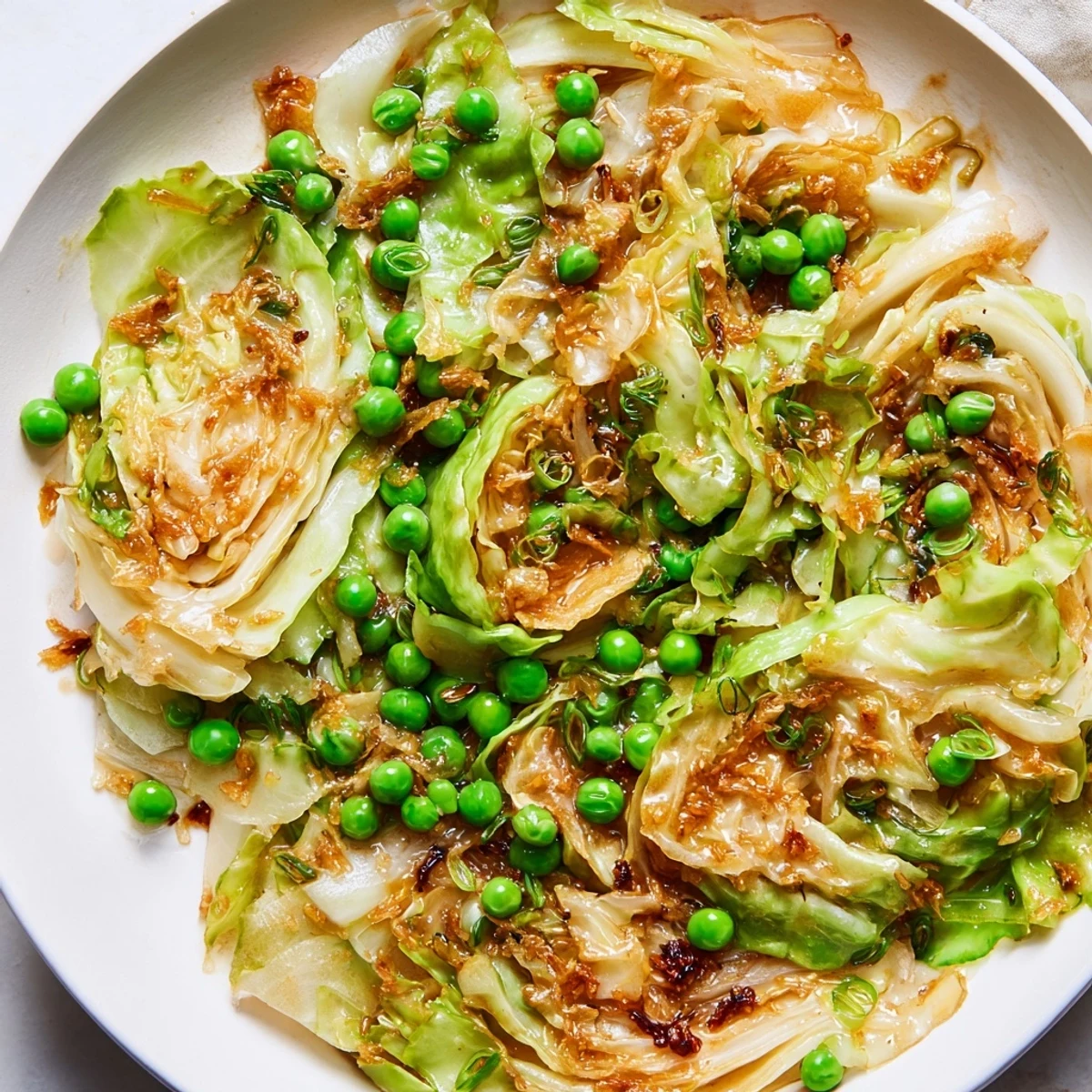 Steaming Cabbage Stir-Fry with garlic and peas, glistening with soy sauce, ready to serve hot.