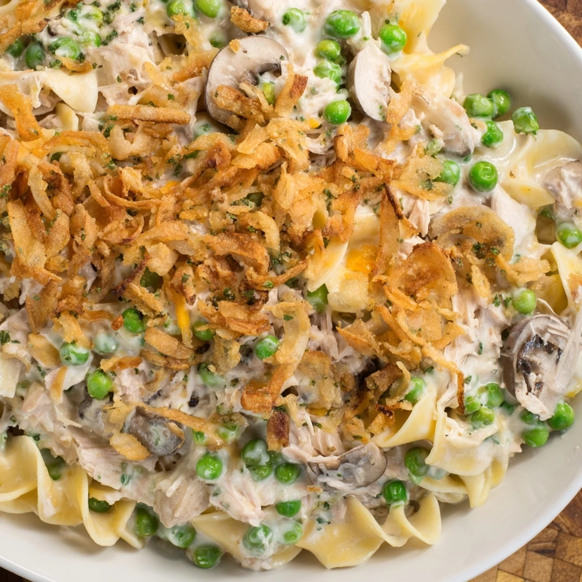 Golden, bubbly homemade Tuna Noodle Casserole topped with crispy onions, ready for a warm meal.