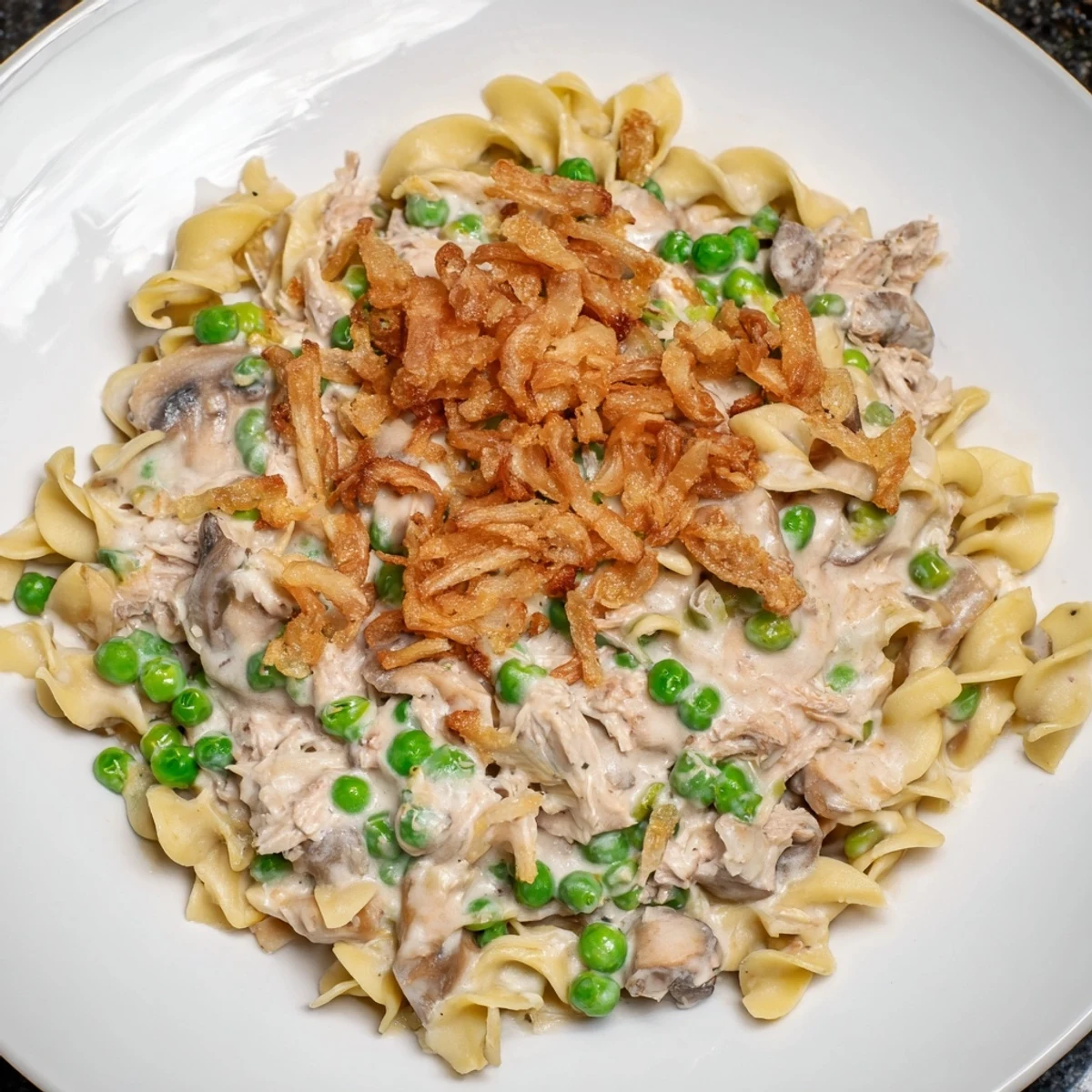 This Tuna Noodle Casserole recipe shows a hearty, creamy dish with savory flavors and vegetables.