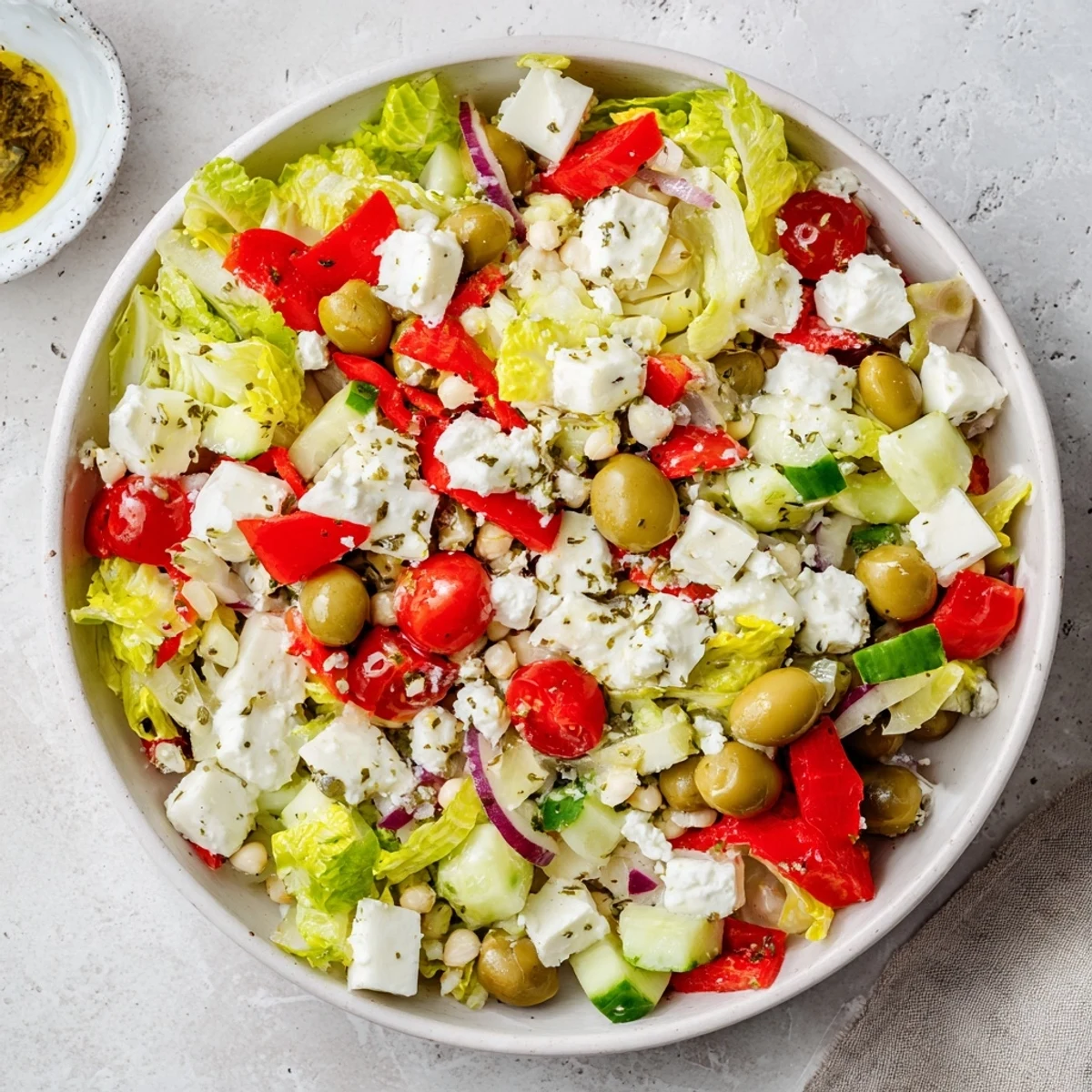 Enjoy a refreshing bite of La Scala Chopped Chickpea Salad, piled high with cheese and drizzled dressing.