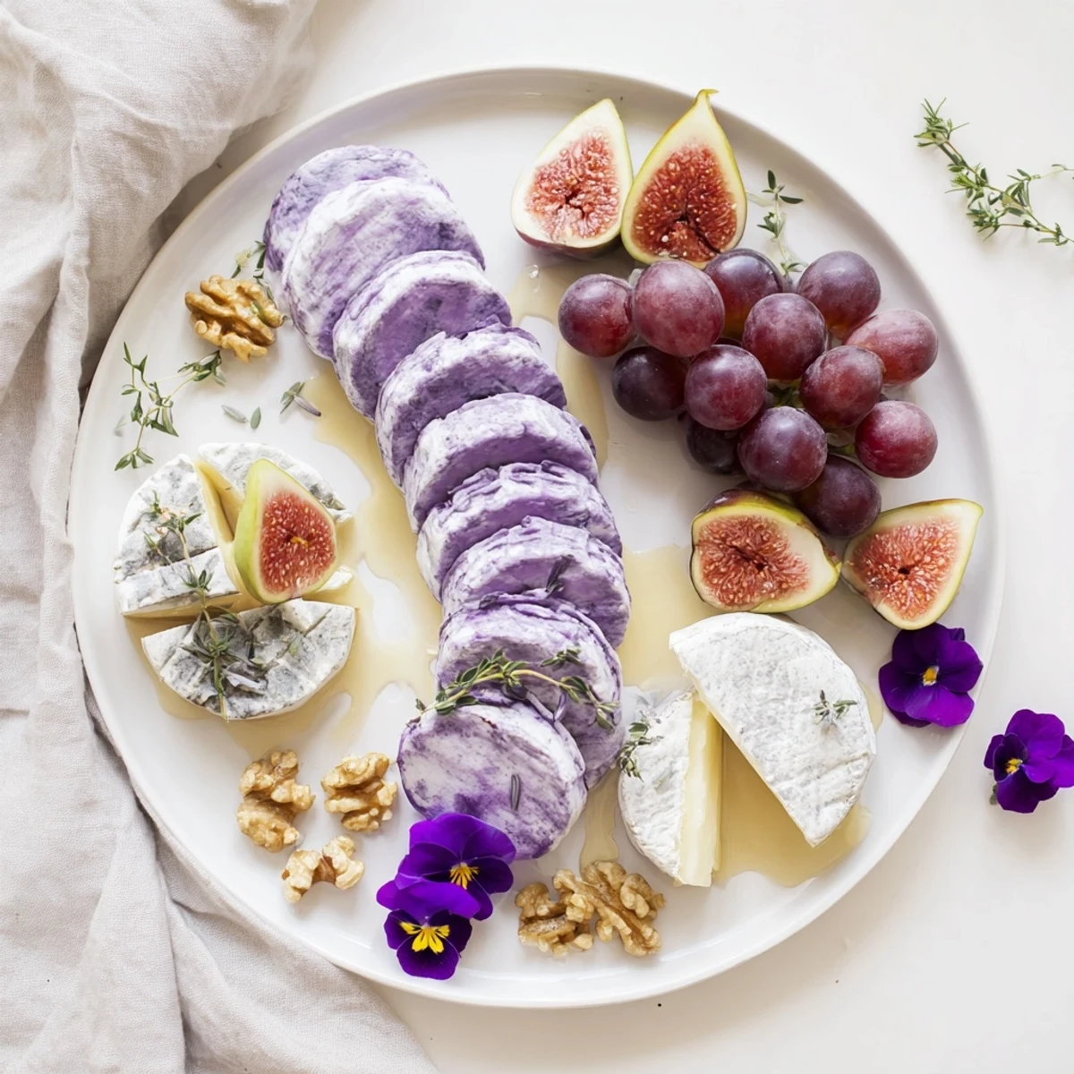 This elegant "Lavender Haze" appetizer showcases creamy brie, figs, and candied nuts on a platter.