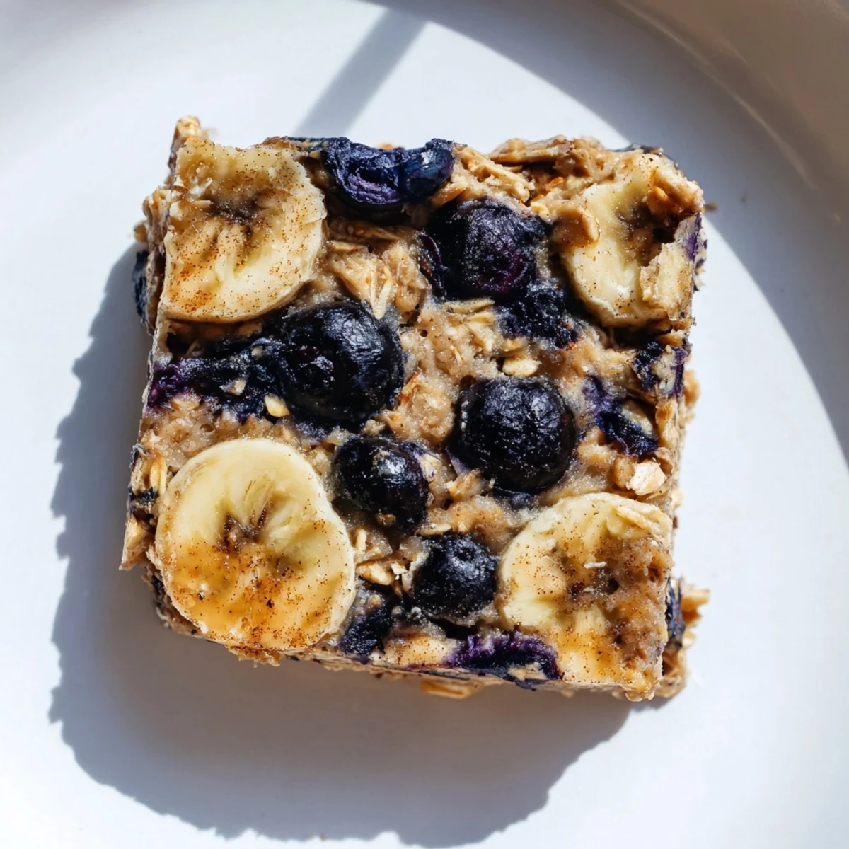 Golden-brown Blueberry Banana Oatmeal Protein Bars with bursts of juicy blueberries: a healthy breakfast.