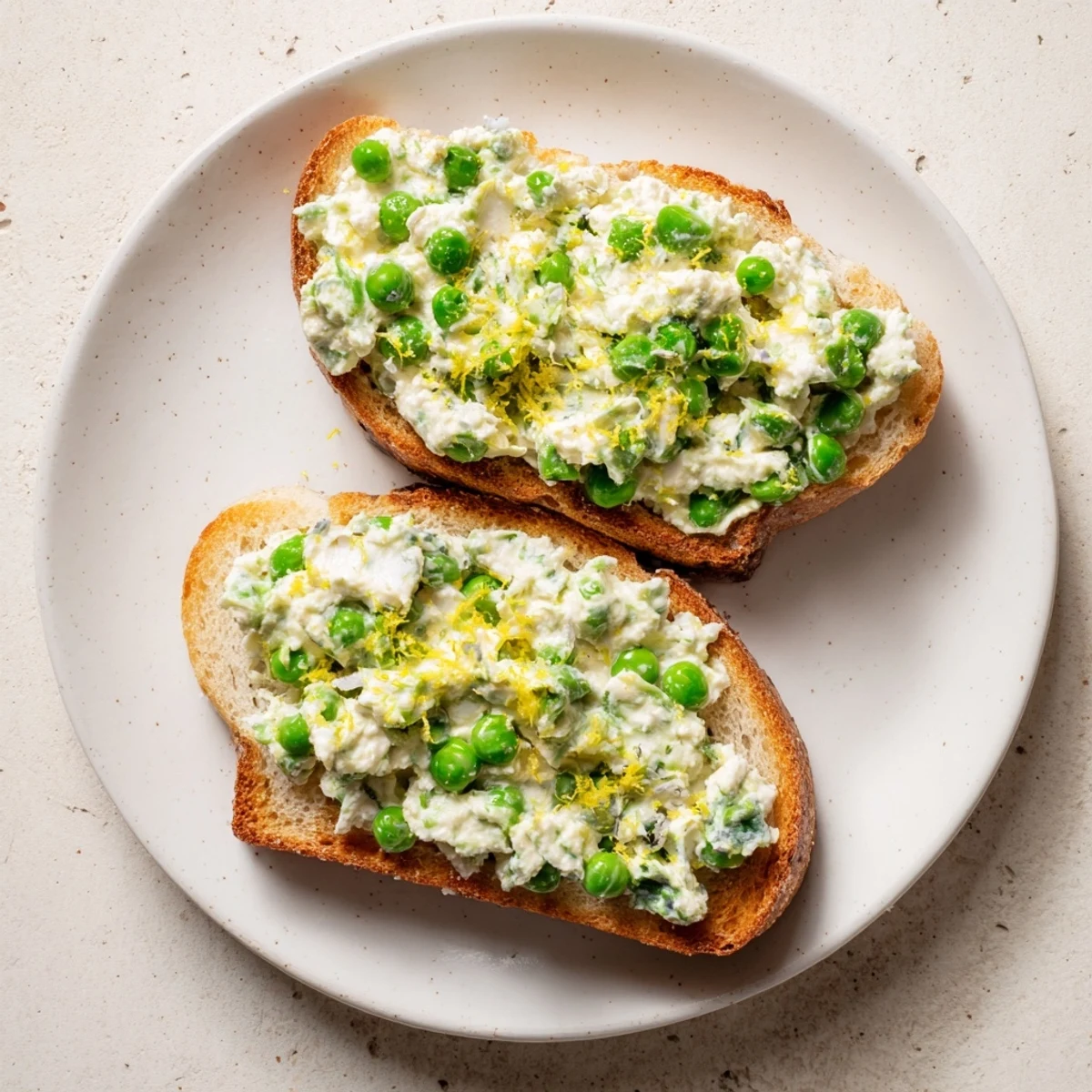Crisp sourdough toast topped with creamy Pea & Mint Ricotta spread, finished with fresh lemon zest and a drizzle of olive oil.