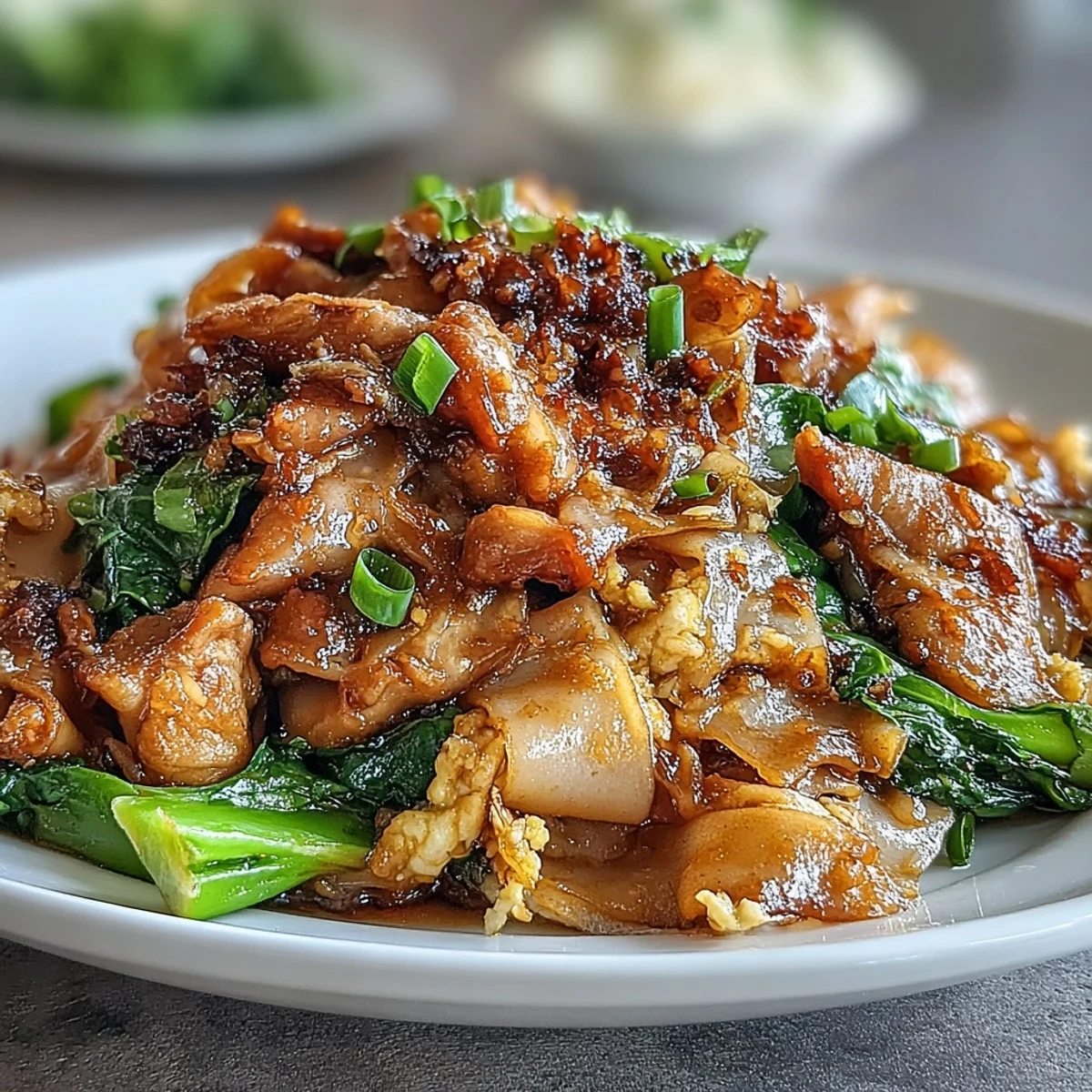 Authentic Thai Pad See Ew with glossy, wide rice noodles, tender chicken, and Chinese broccoli in a rich, savory-sweet sauce.