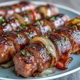 A sheet pan of juicy sausages roasted with colorful bell peppers and sweet onions, served hot for a quick dinner.