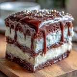 Three-tier vanilla sponge cake frosted with silky white chocolate buttercream and topped with shimmering gold balloon candies.