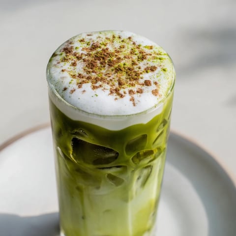 Iced Matcha Latte with cinnamon roll protein foam offers a refreshing, vibrant, layered look.