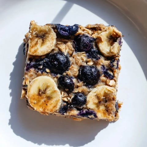 Golden-brown Blueberry Banana Oatmeal Protein Bars with bursts of juicy blueberries: a healthy breakfast.