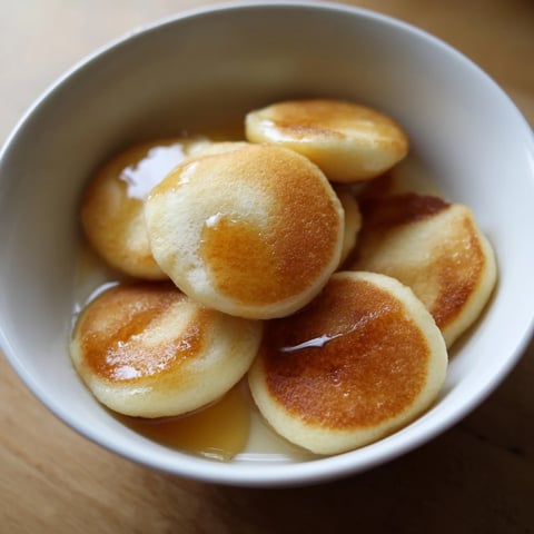 Fluffy Pancake Cereal: Golden-brown mini pancakes piled in a bowl, ready for syrup and milk.