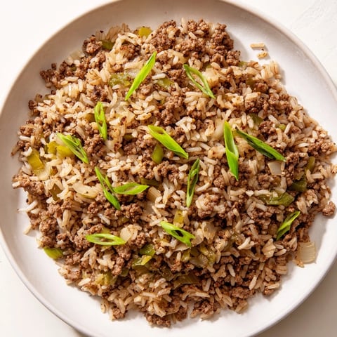 Sizzling Cajun Dirty Rice featuring browned ground meats and vegetables, ready to serve and enjoy.