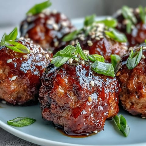 Oven-baked Spicy Chili Honey Turkey Meatballs coated in a glossy, sweet heat glaze and sprinkled with sesame seeds.