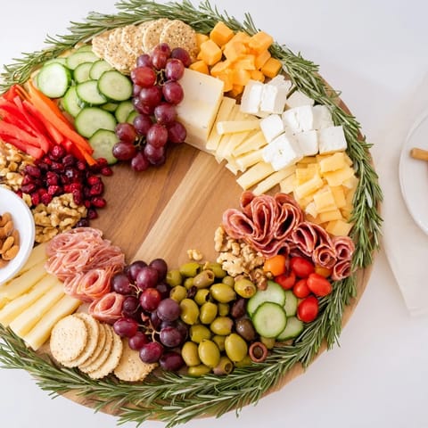 This eye-catching Simplified Grazing Board Wreath features cheeses, charcuterie, and fresh produce displayed beautifully.