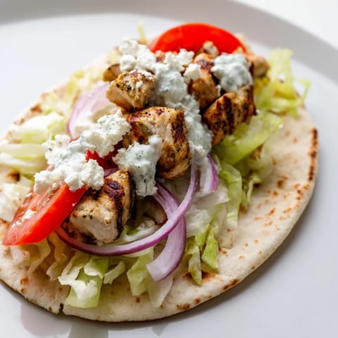 Glimpse the deliciousness of Greek Chicken Souvlaki Wraps: grilled chicken, veggies, and sauce tucked in pita.