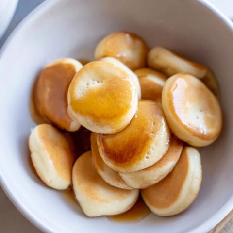 Warm and delightful: A bowlful of Fluffy Pancake Cereal drizzled with sweet maple syrup.