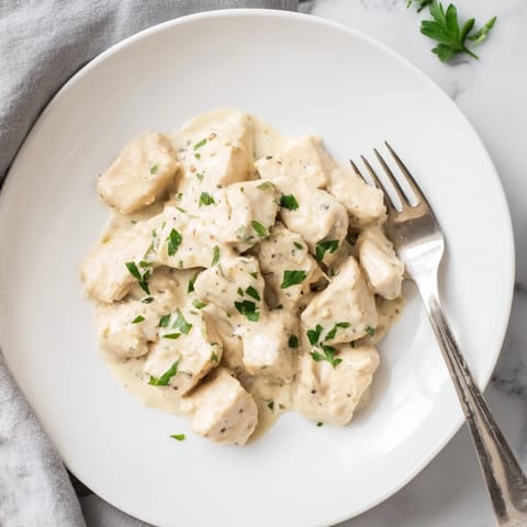 Tender golden chicken bites coated in a rich, garlicky cream sauce with fresh parsley, perfect for a quick weeknight dinner.