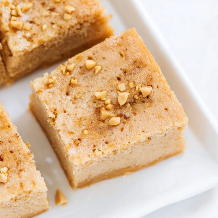 Warm Peanut Butter Mochi Cake with a glistening, subtly sweet surface; imagine that soft, rich flavor.