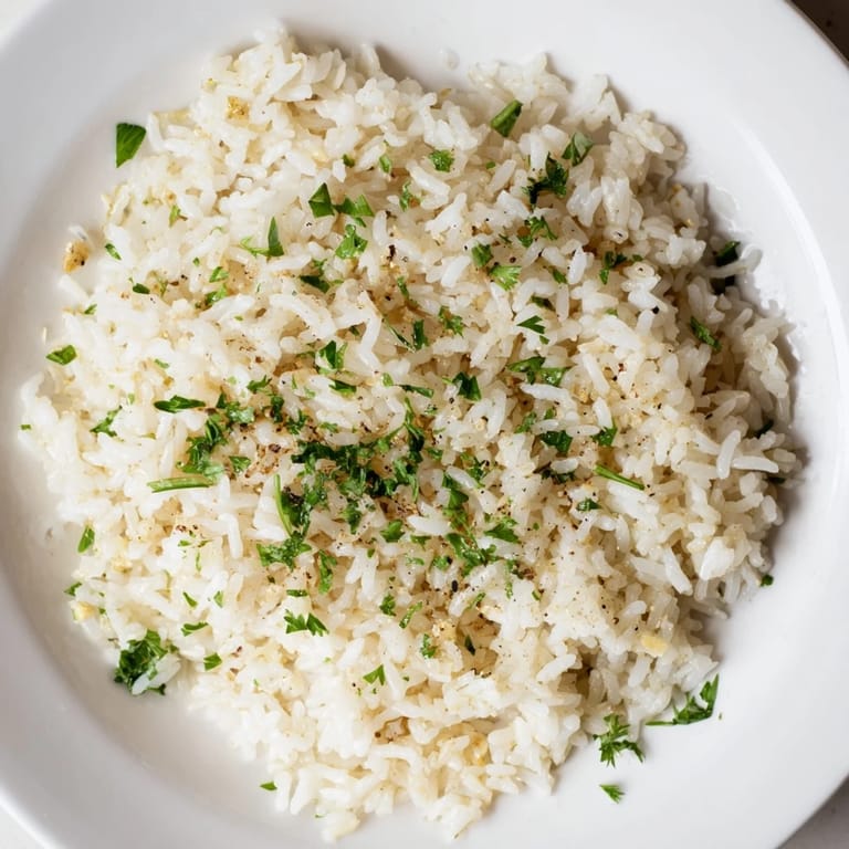 A steaming bowl showcasing golden Garlic Butter Rice, a comforting side dish with subtle garlic flavor.