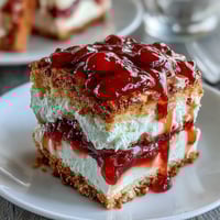 Golden thumbprint cookies with creamy clotted cream and vibrant strawberry jam centers, perfect for afternoon tea.